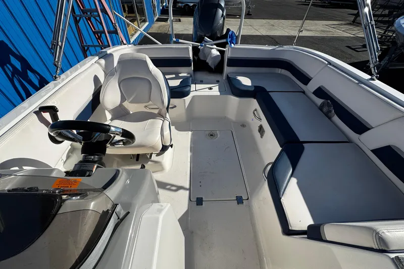 Slide: The Image of 2019 Chaparral 191 Suncoast boat interior with steering wheel and seating. - 14