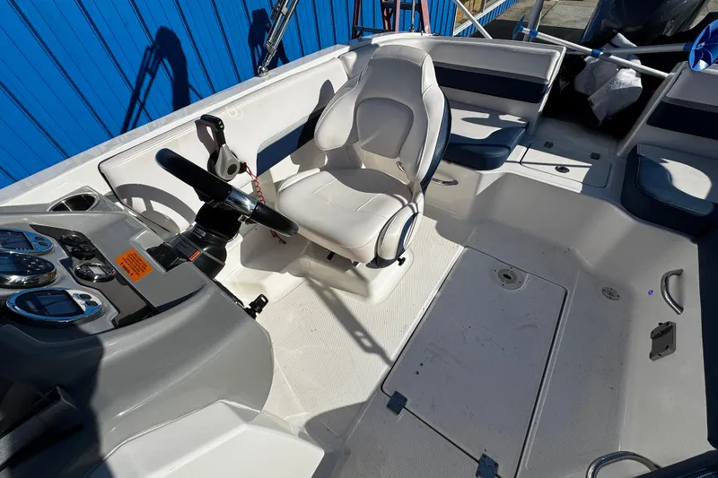 Slide: The Image of 2019 Chaparral 191 Suncoast boat interior with steering wheel and seating. - 16