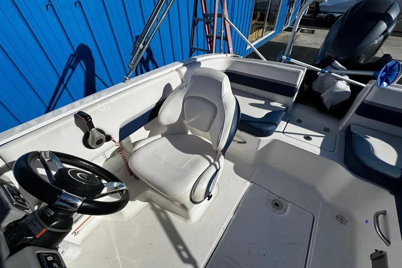 Slide: The Image of 2019 Chaparral 191 Suncoast boat interior with steering wheel and seating. - 18