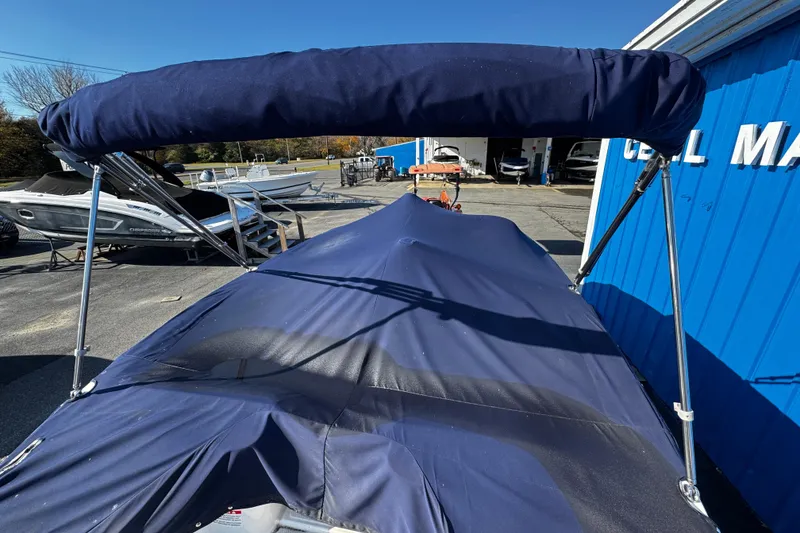 Slide: The Image of 2019 Chaparral 191 Suncoast boat with blue cover and canopy in marina setting. - 28