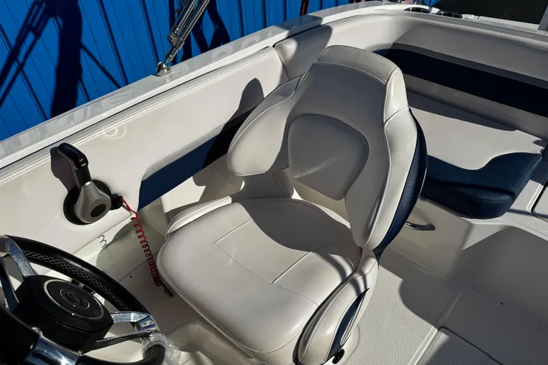 Slide: The Image of 2019 Chaparral 191 Suncoast boat interior with white captain's chair and steering wheel. - 4