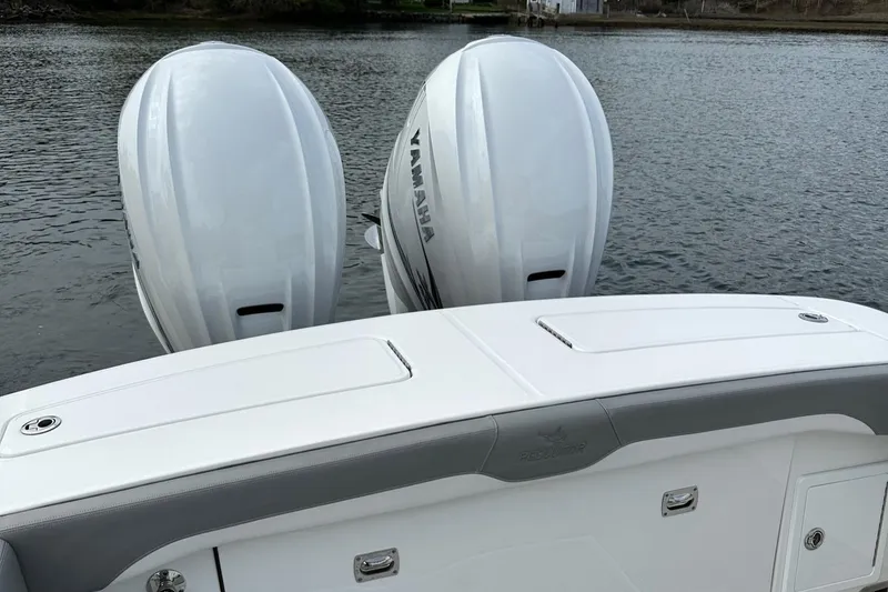 Slide: The Image of 2023 Regulator 34 boat with twin Yamaha outboard engines on a calm water surface. - 14