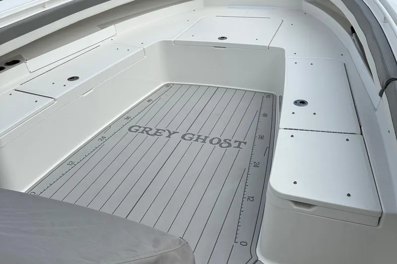 Slide: The Image of 2023 Regulator 34 boat deck with "Grey Ghost" branding and storage compartments. - 19