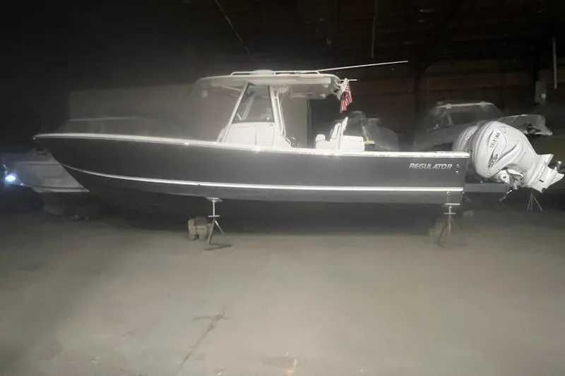Slide: The Image of 2023 Regulator 34 boat in storage, side view with Yamaha outboard engines. - 4