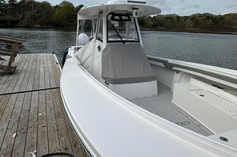 Slide: The Image of 2023 Regulator 34 boat docked by a wooden pier on a calm lake. - 8