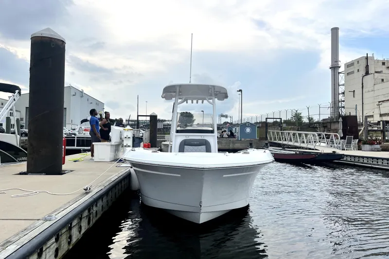 Slide: The Image of 2024 NauticStar 222L Offshore boat docked at marina with people nearby. - 3