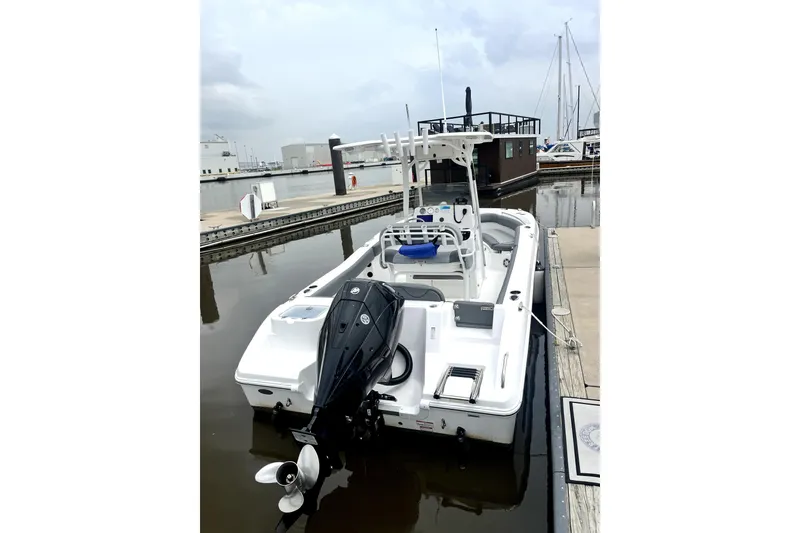Slide: The Image of 2024 NauticStar 222L Offshore boat docked at marina, rear view. - 4