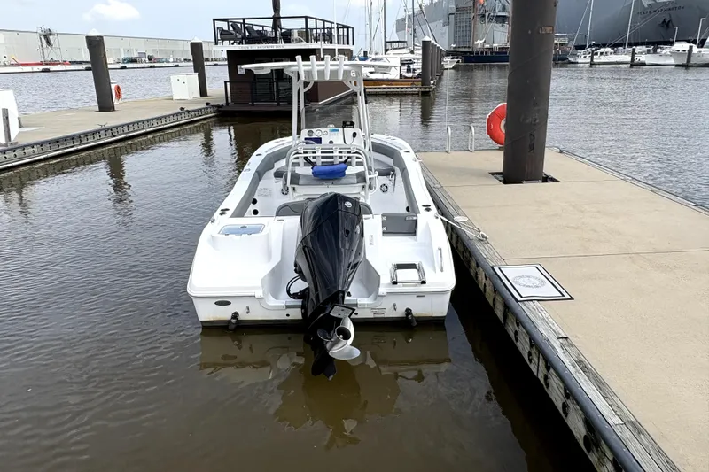 Slide: The Image of 2024 NauticStar 222L Offshore boat docked at marina, rear view. - 5