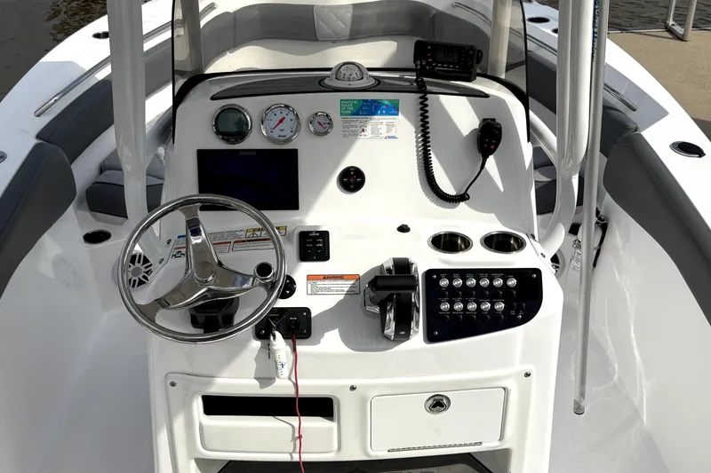 Slide: The Image of 2024 NauticStar 222L Offshore boat dashboard with steering wheel, gauges, and controls. - 6
