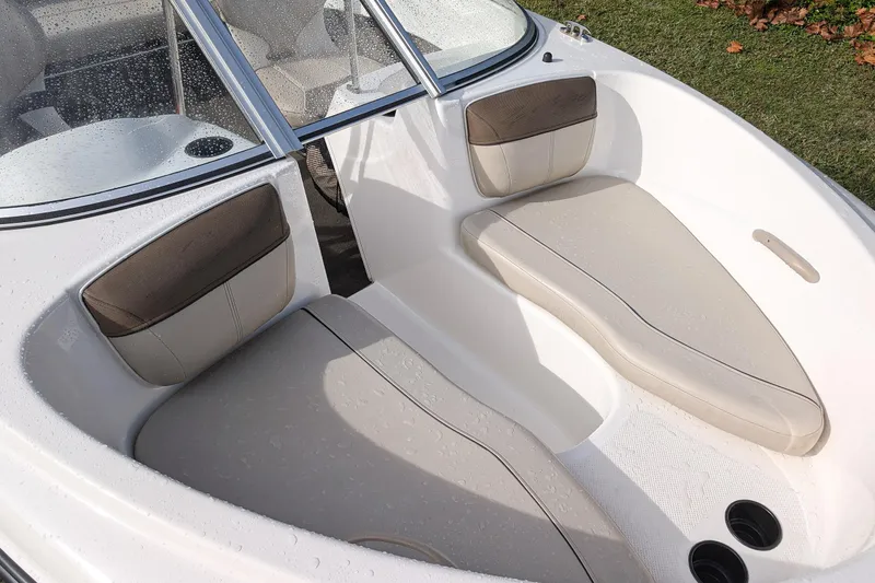 Slide: The Image of 2016 Bayliner 160 Bowrider interior with beige seating and cup holders. - 5