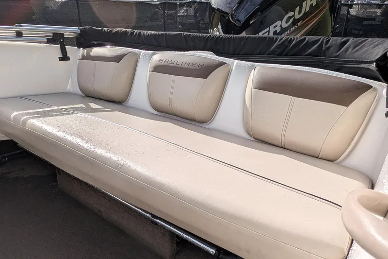 Slide: The Image of 2016 Bayliner 160 Bowrider interior seating with beige and brown upholstery. - 7