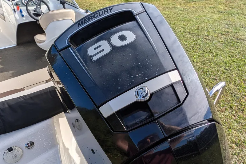 Slide: The Image of 2016 Bayliner 160 Bowrider with Mercury 90 engine, parked on grass. - 8