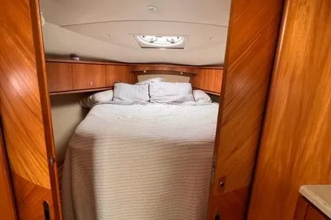 Slide: The Image of 2008 Tiara Yachts 3900 Sovran cabin with cozy bed and wooden interior. - 22