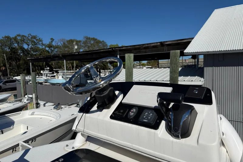 Slide: The Image of 2022 Tidewater 2500 Carolina Bay boat console with steering wheel and controls. - 13