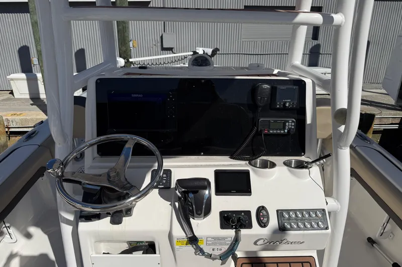 Slide: The Image of 2022 Tidewater 2500 Carolina Bay boat console with steering wheel and navigation controls. - 8