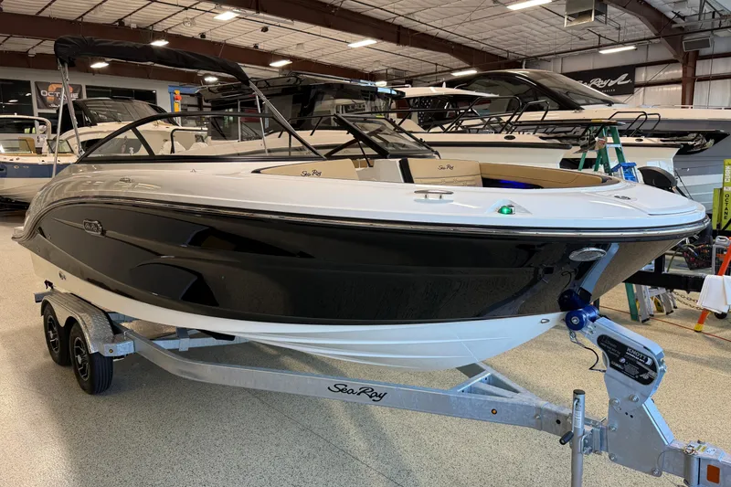 Slide: The Image of 2026 Sea Ray SPX 210 Outboard boat displayed in a showroom on a trailer. - 17