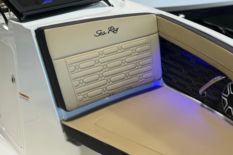 Slide: The Image of 2026 Sea Ray SPX 210 Outboard boat interior with beige seating and blue accent lighting. - 20