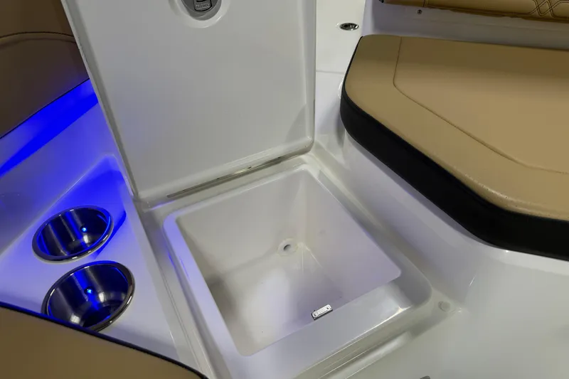 Slide: The Image of 2026 Sea Ray SPX 210 Outboard boat interior with storage compartment and cup holders. - 23