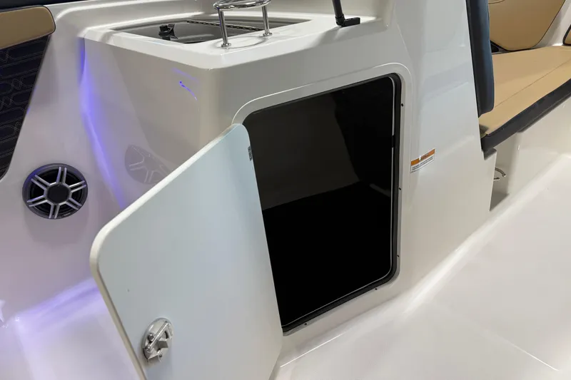 Slide: The Image of 2026 Sea Ray SPX 210 Outboard interior with open storage compartment and speaker. - 30