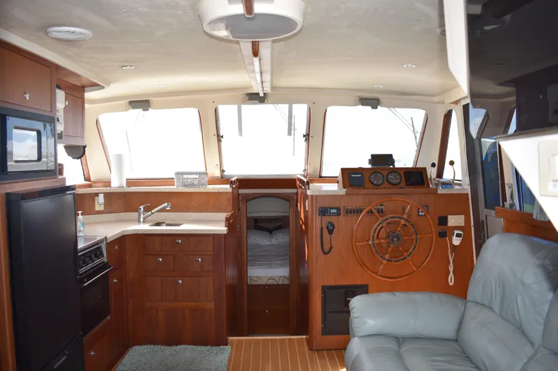 Slide: The Image of Interior of 2001 Mainship 390 yacht with kitchen, steering wheel, and seating area. - 10