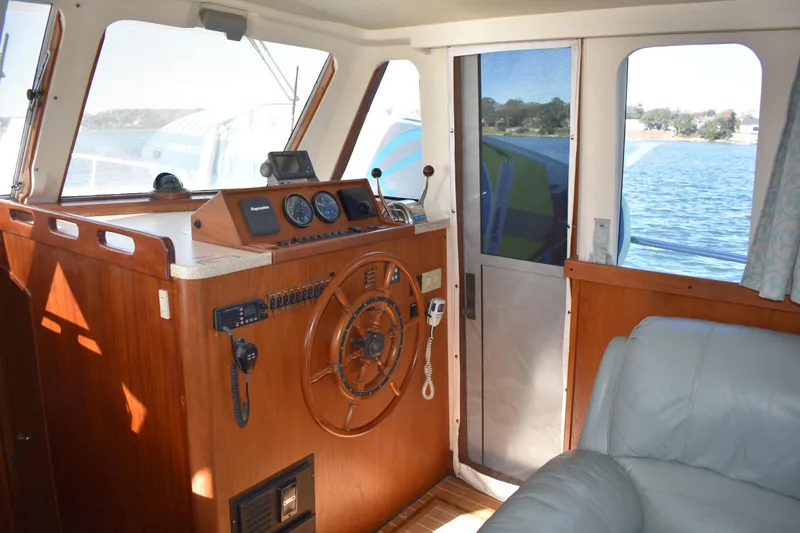 Slide: The Image of Interior helm of 2001 Mainship 390 boat with wooden steering wheel and navigation instruments. - 11