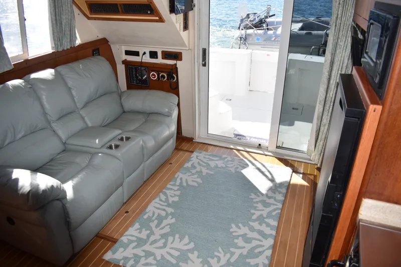 Slide: The Image of Interior of 2001 Mainship 390 yacht with leather sofa and ocean view through glass door. - 15