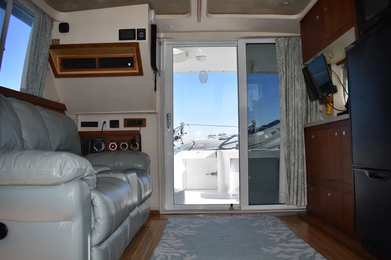 Slide: The Image of Interior of 2001 Mainship 390 yacht with leather seating and sliding glass door. - 16