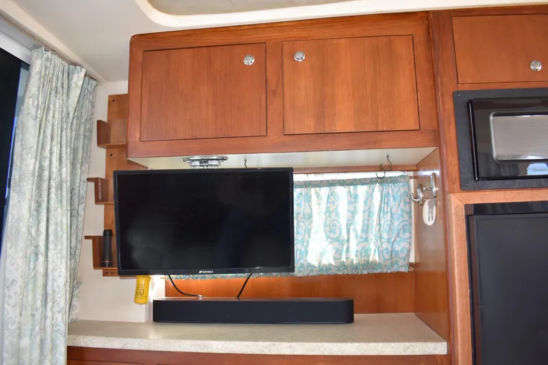 Slide: The Image of Interior of 2001 Mainship 390 with mounted TV and wooden cabinetry. - 19
