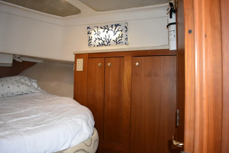 Slide: The Image of 2001 Mainship 390 cabin interior with bed, wooden cabinets, and nautical decor. - 28