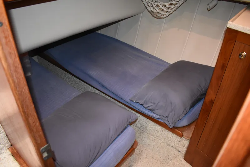 Slide: The Image of Cozy twin beds in 2001 Mainship 390 cabin with blue bedding and wooden accents. - 30