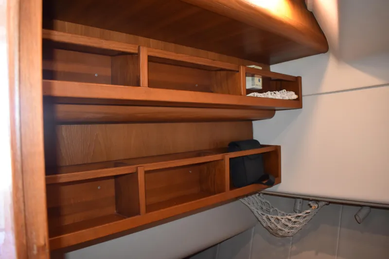 Slide: The Image of Wooden shelves in a 2001 Mainship 390 boat interior, featuring storage compartments. - 31