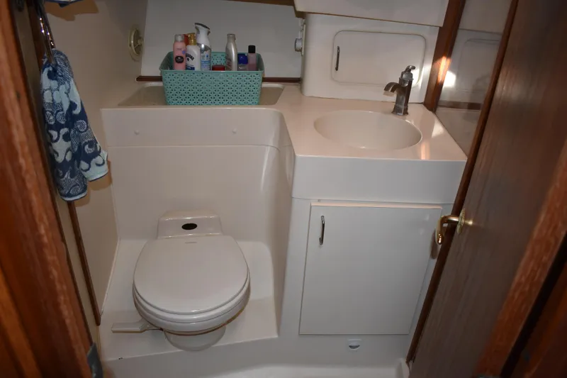 Slide: The Image of 2001 Mainship 390 boat bathroom with toilet, sink, and toiletries. - 32