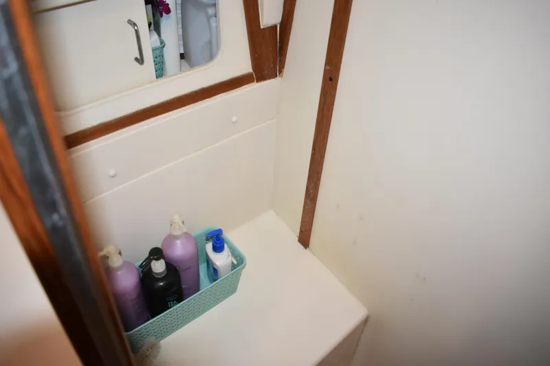 Slide: The Image of Bathroom storage area on 2001 Mainship 390 with toiletries in a basket. - 36