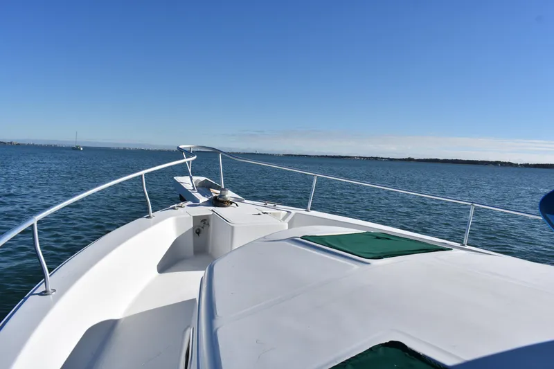 Slide: The Image of 2001 Mainship 390 boat deck view on calm water under clear blue sky. - 39