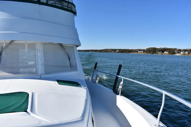Slide: The Image of 2001 Mainship 390 cruising on a serene lake under clear blue skies. - 42
