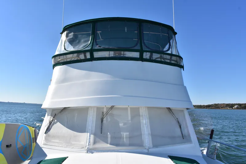 Slide: The Image of 2001 Mainship 390 boat on water, featuring enclosed flybridge and clear blue sky. - 43