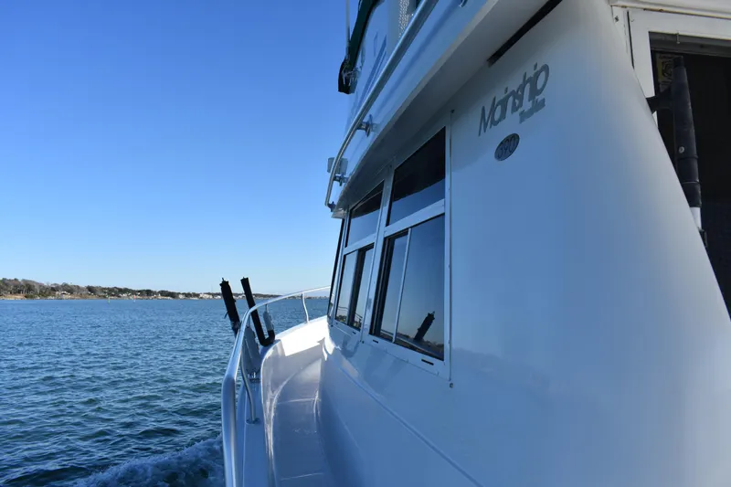Slide: The Image of 2001 Mainship 390 boat cruising on a calm blue sea under a clear sky. - 45