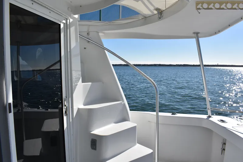 Slide: The Image of 2001 Mainship 390 yacht with stairs, overlooking serene ocean view. - 48