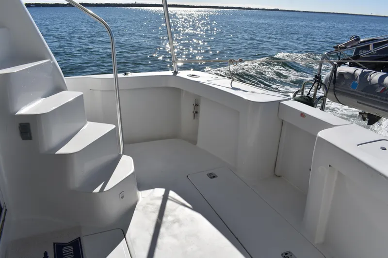 Slide: The Image of 2001 Mainship 390 boat deck with stairs, overlooking sparkling water. - 49