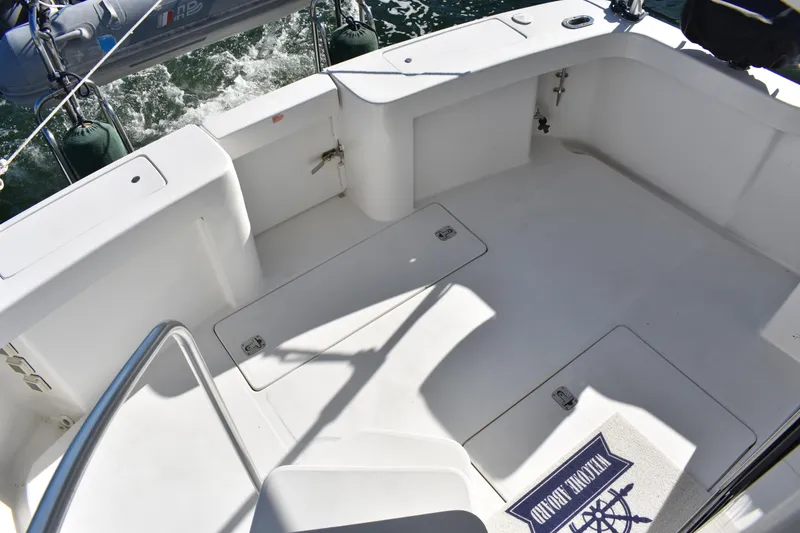 Slide: The Image of 2001 Mainship 390 boat deck with storage hatches and nautical-themed mat. - 51