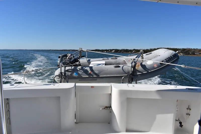 Slide: The Image of 2001 Mainship 390 yacht towing an inflatable boat on a sunny day. - 52