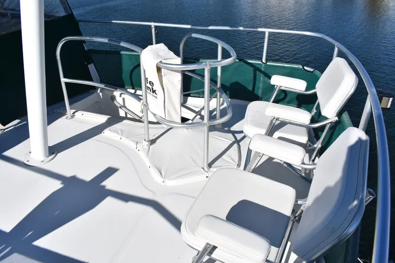 Slide: The Image of Flybridge seating area on a 2001 Mainship 390 yacht, featuring white cushioned chairs. - 57