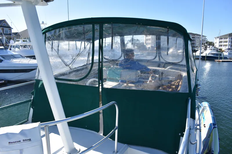 Slide: The Image of 2001 Mainship 390 yacht with enclosed cockpit, docked in a marina. - 59