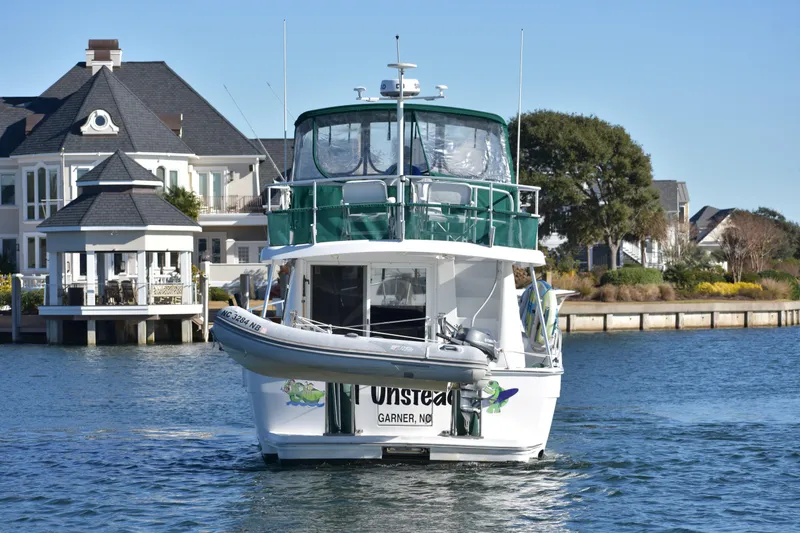 Slide: The Image of 2001 Mainship 390 yacht cruising near waterfront homes. - 6