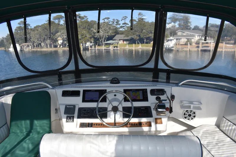 Slide: The Image of Interior view of 2001 Mainship 390 boat helm with scenic waterfront backdrop. - 61