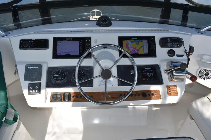 Slide: The Image of Control panel of a 2001 Mainship 390 boat with navigation equipment and steering wheel. - 64