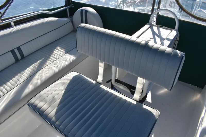 Slide: The Image of 2001 Mainship 390 boat interior with white cushioned seating and table. - 65