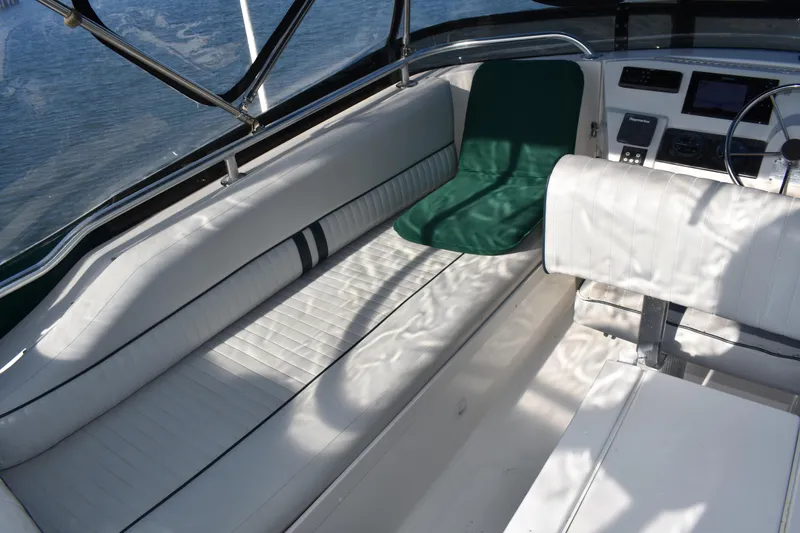 Slide: The Image of 2001 Mainship 390 boat interior with white seating and green cushion. - 68