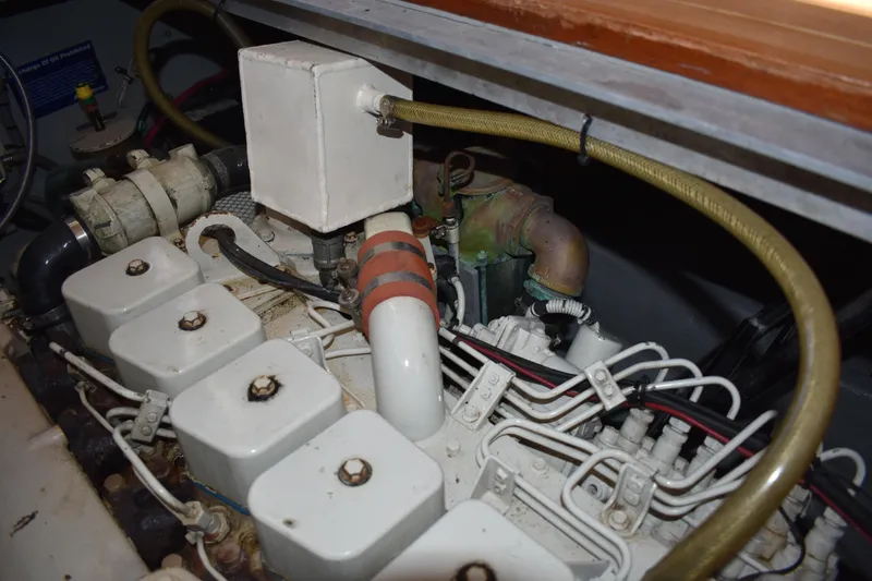 Slide: The Image of Engine compartment of a 2001 Mainship 390 boat, showcasing mechanical components and wiring. - 75