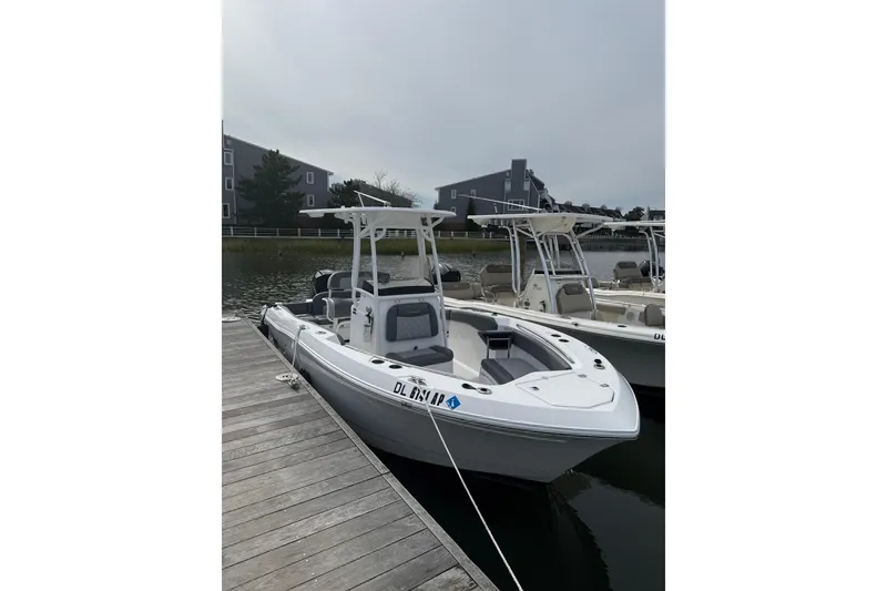 The Image of 2024 NauticStar 222L Offshore boat docked at marina, overcast sky. - 1